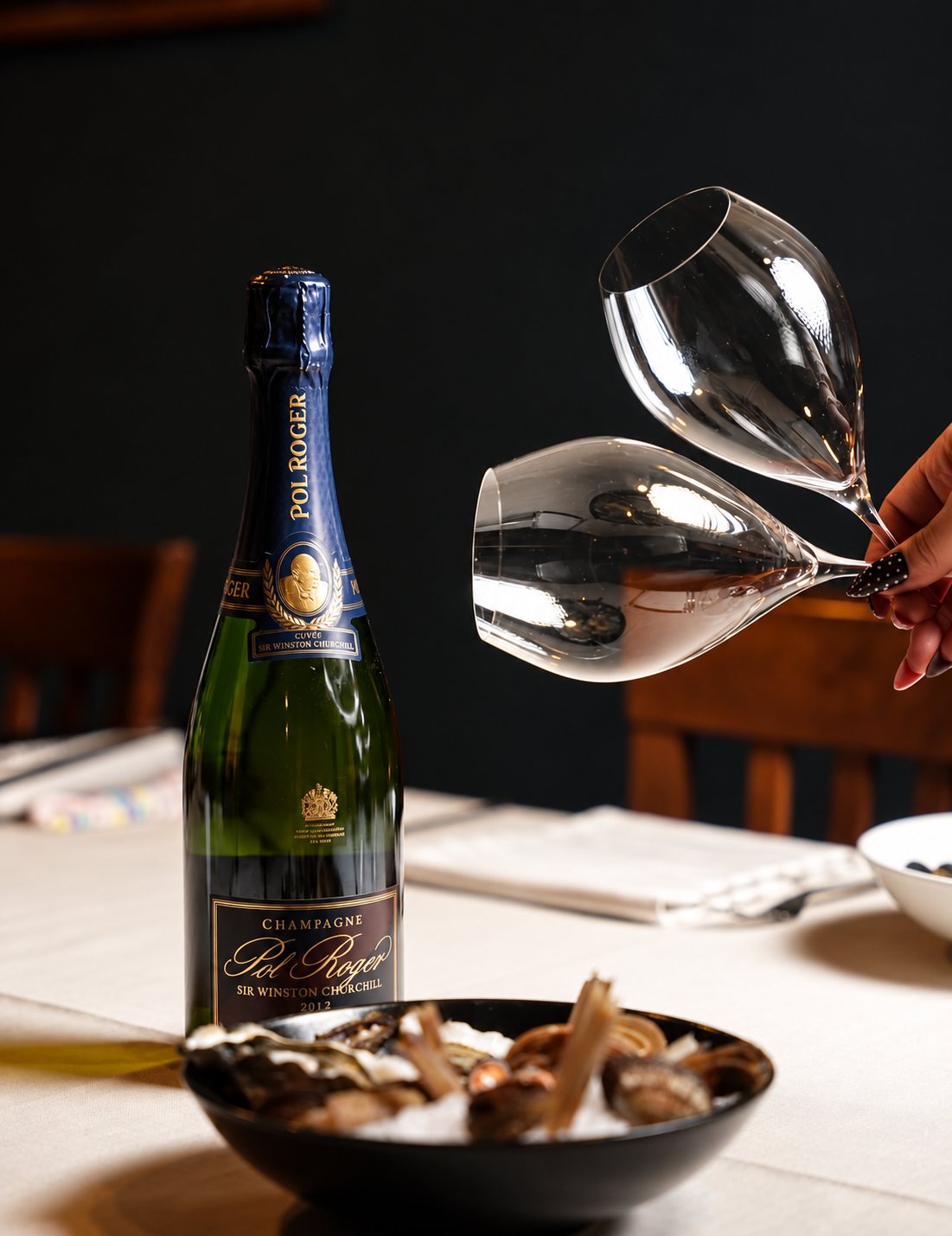 Champagne e calici in sala accanto a un piatto di conchiglie
